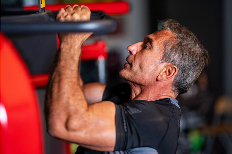 Man performing pull-ups in a gym setting
